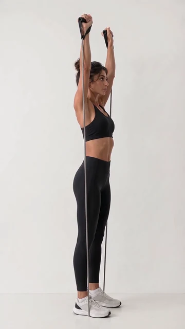 Merissa, VeraForma's AI-generated fitness model, pressing a resistance band overhead, arms straight.